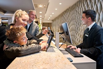 Parents with child are standing at reception desk