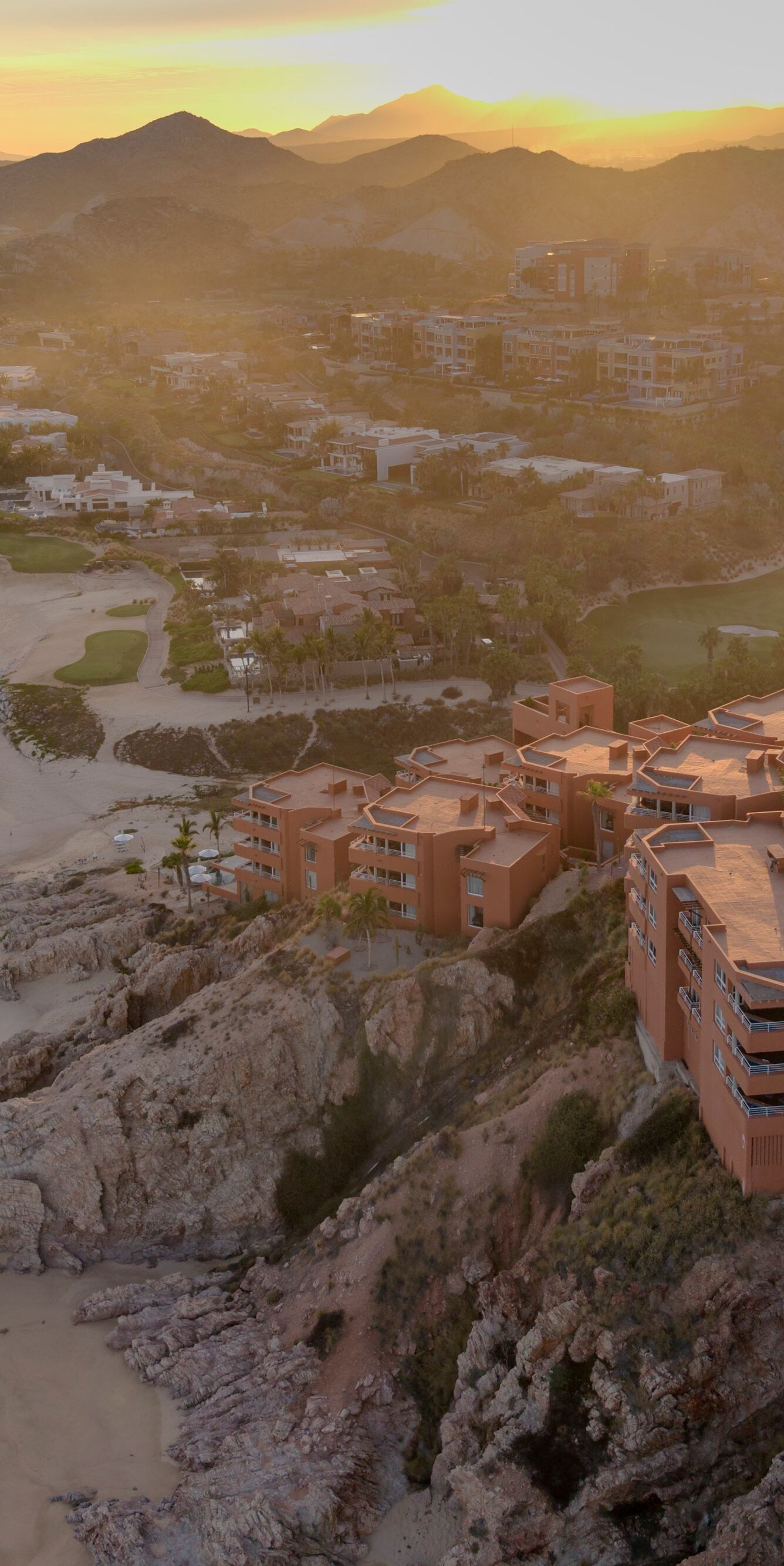 Clifftop resort at sunset above beach and coast