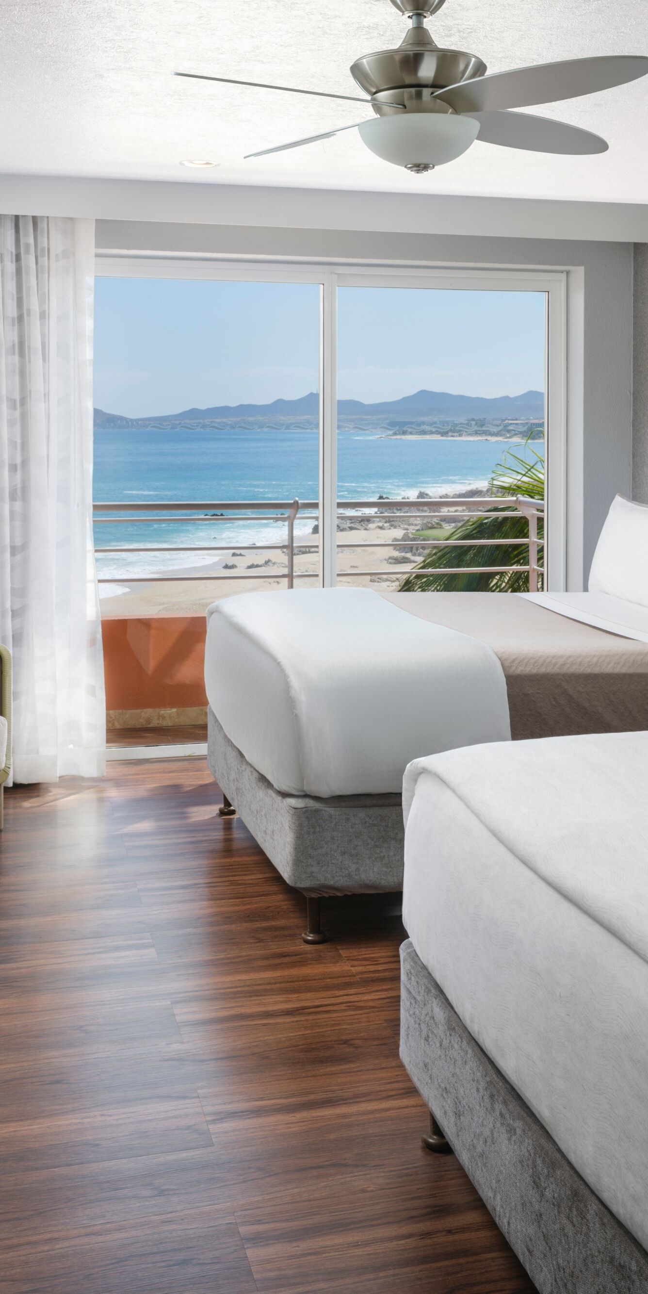 Guest room with two beds and ocean view balcony