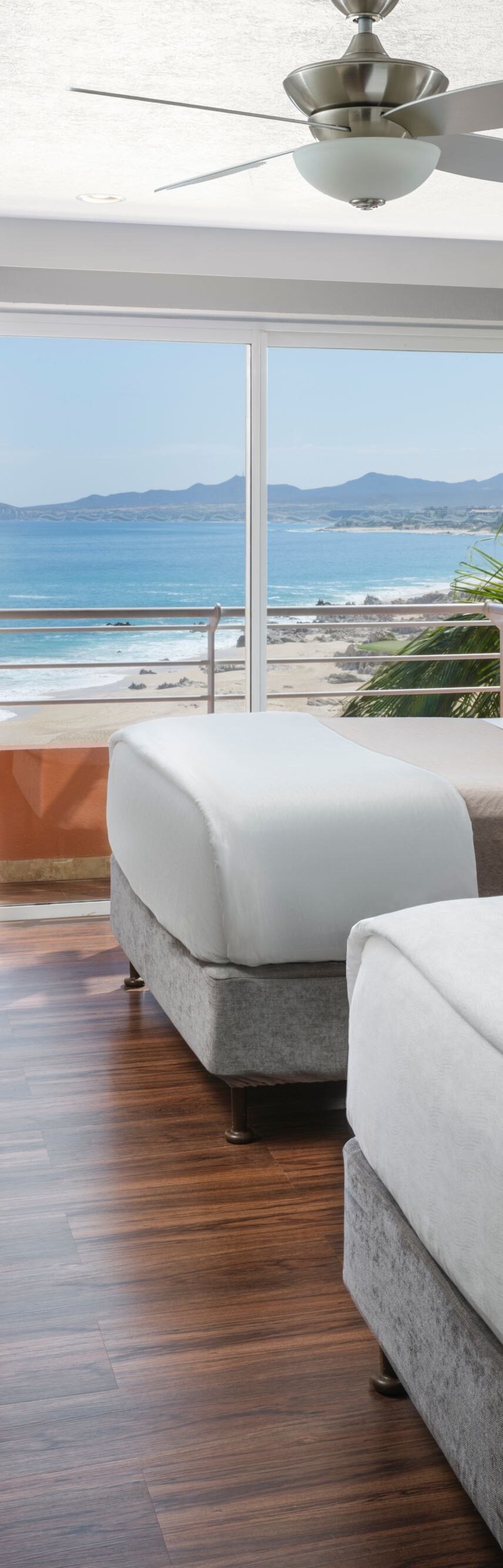 Guest room with two beds and ocean view balcony