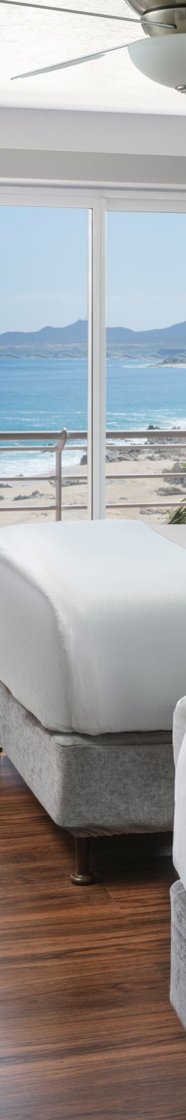 Guest room with two beds and ocean view balcony