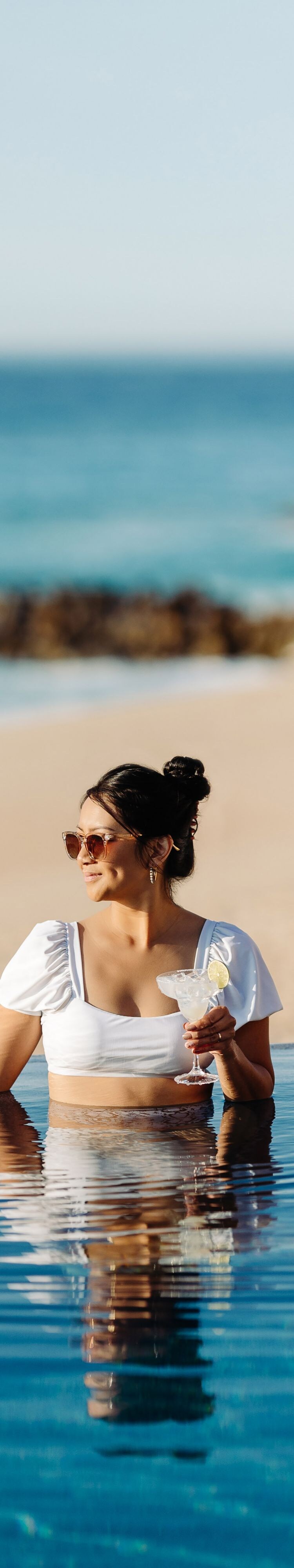 Woman drinking at resort pool in Los Cabos