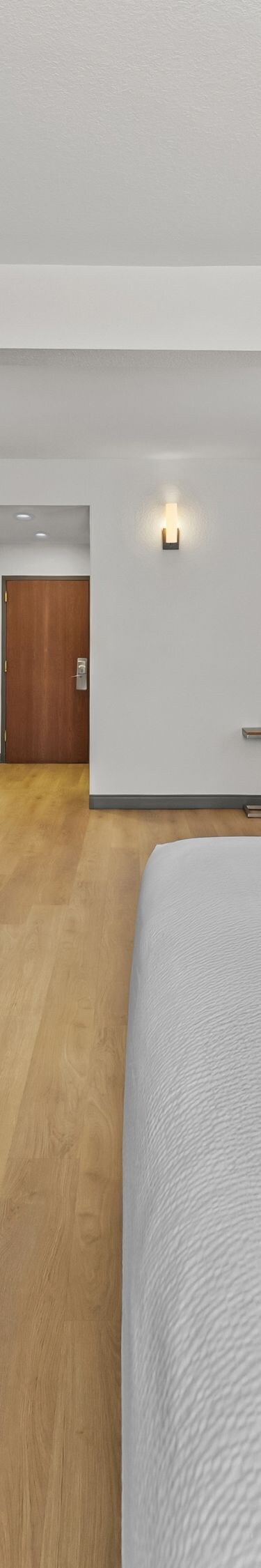 King bed with wall-mounted TV and desk