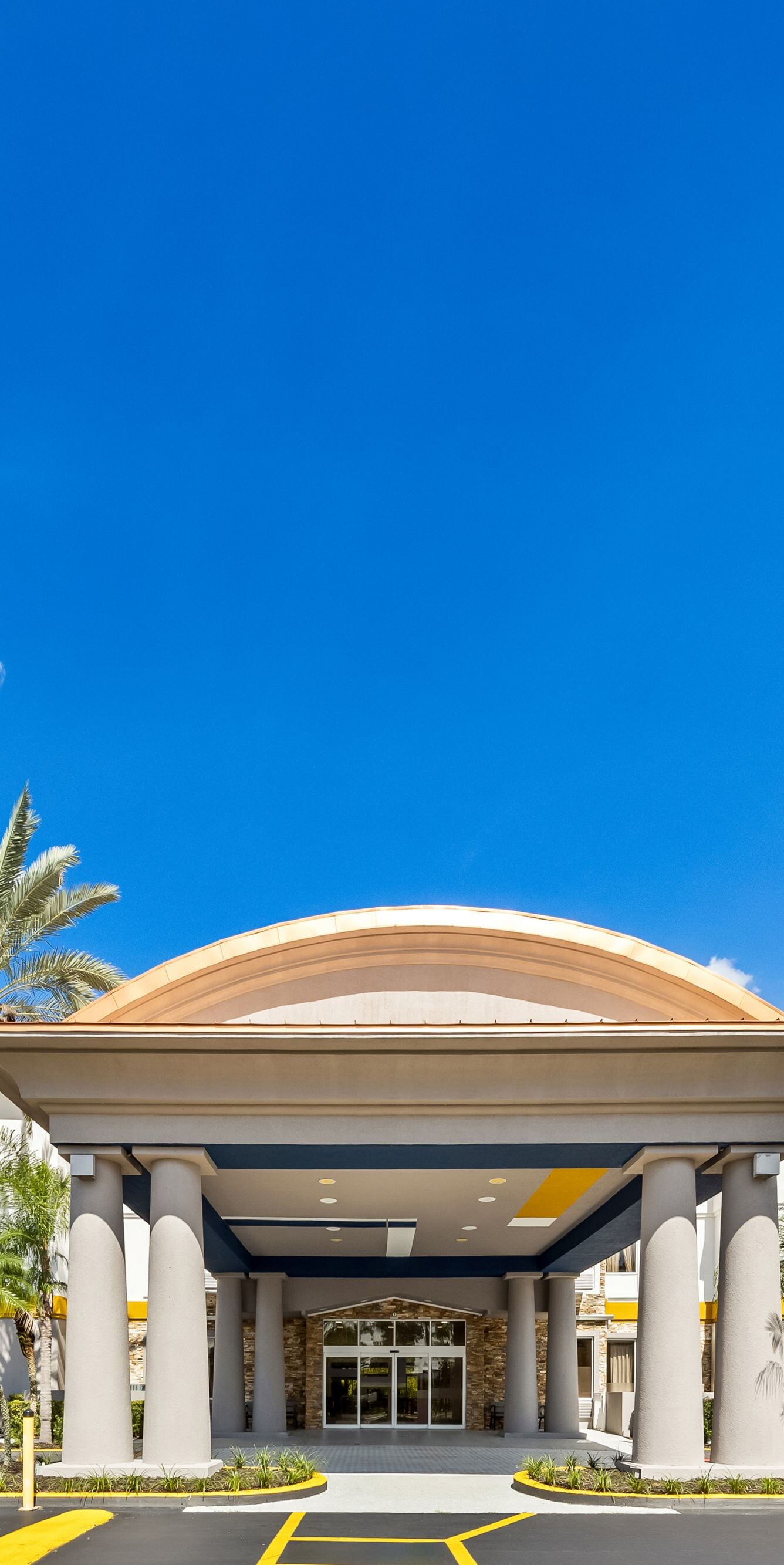 Covered entrance framed by palm trees