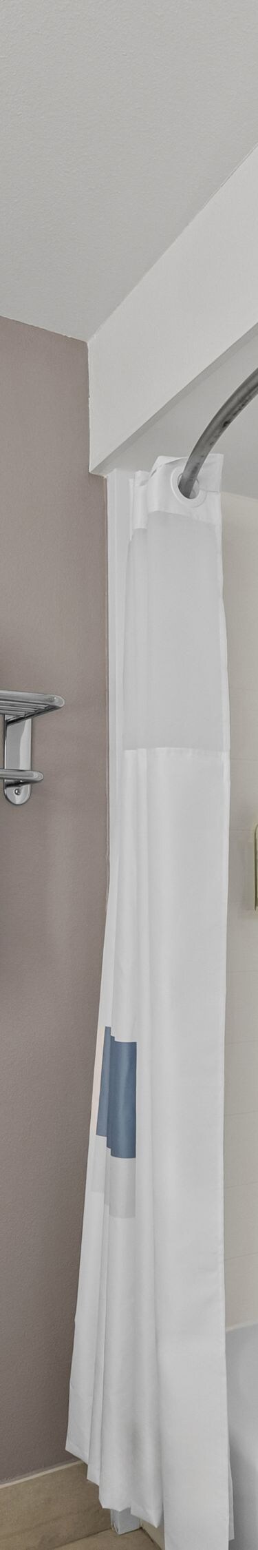 Tub shower with grab bar and toiletries