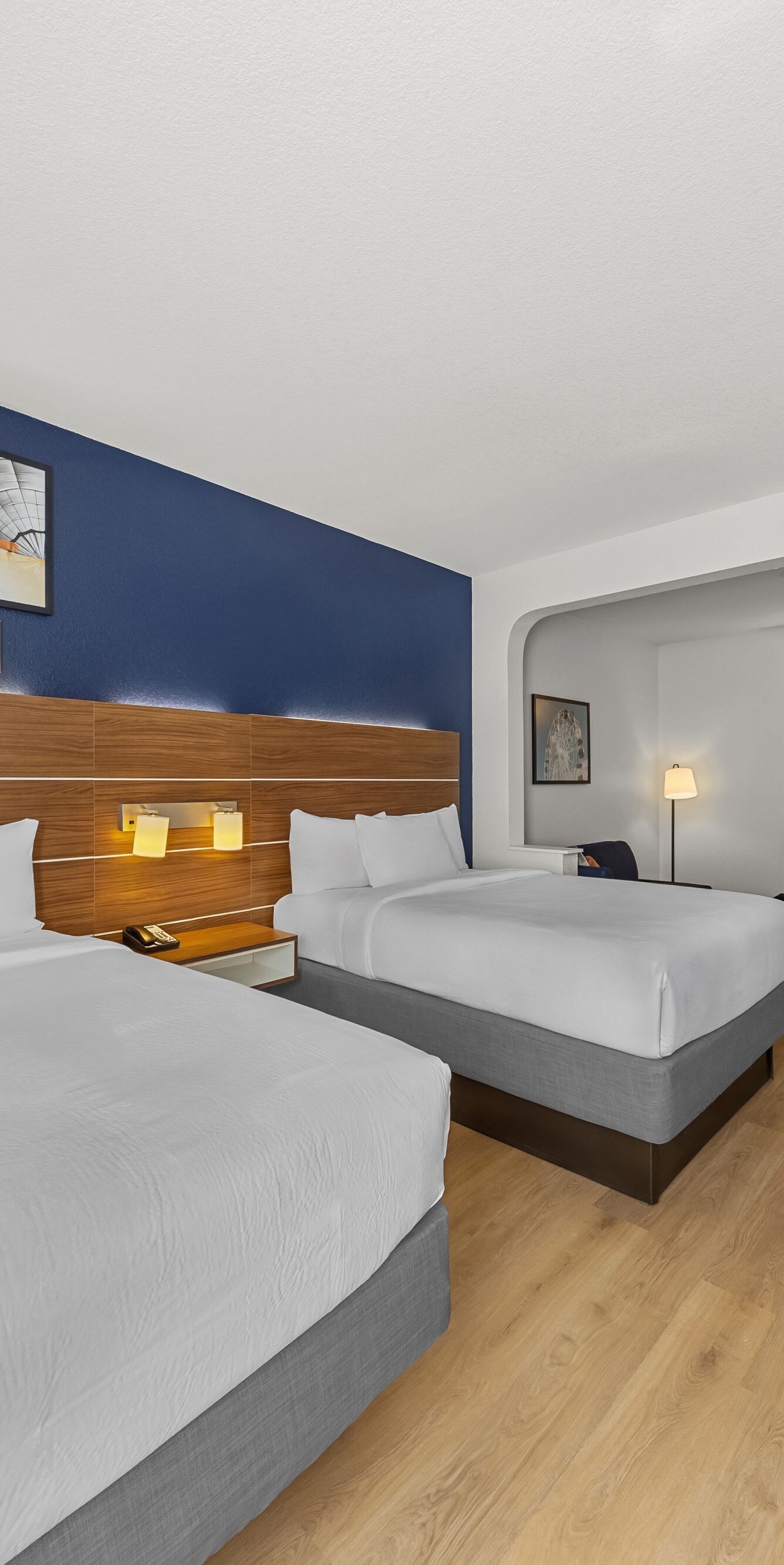 Two queen beds facing wall-mounted TV