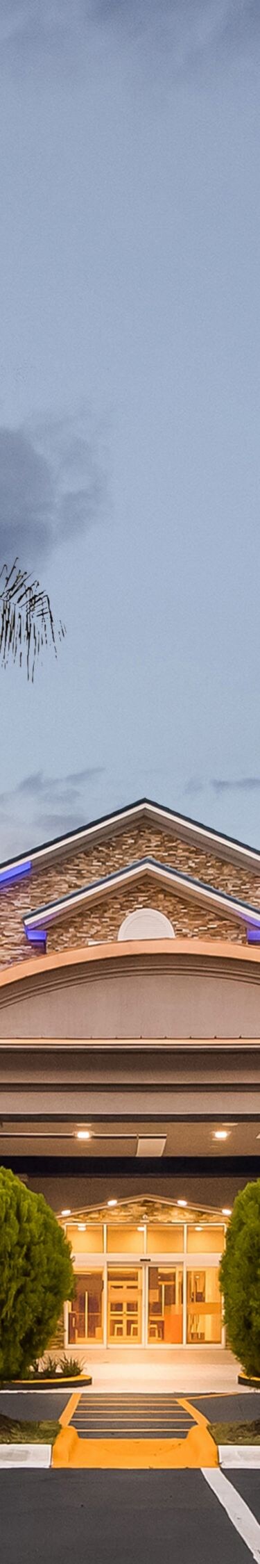Hotel entrance glowing beneath twilight sky