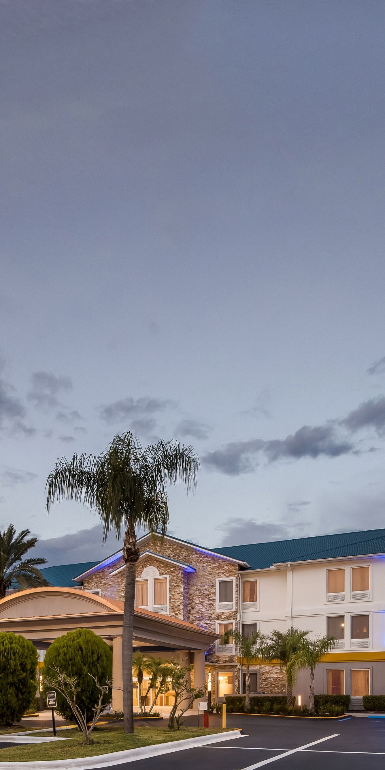 Hotel exterior with roadside sign at dusk