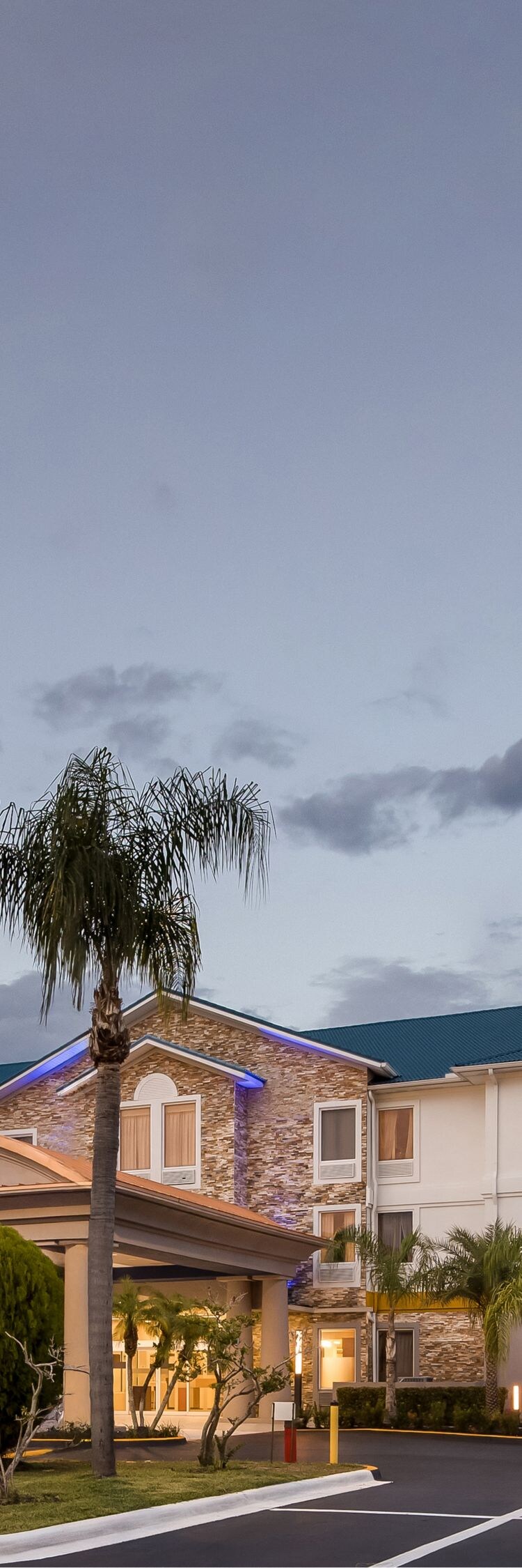 Hotel exterior with roadside sign at dusk