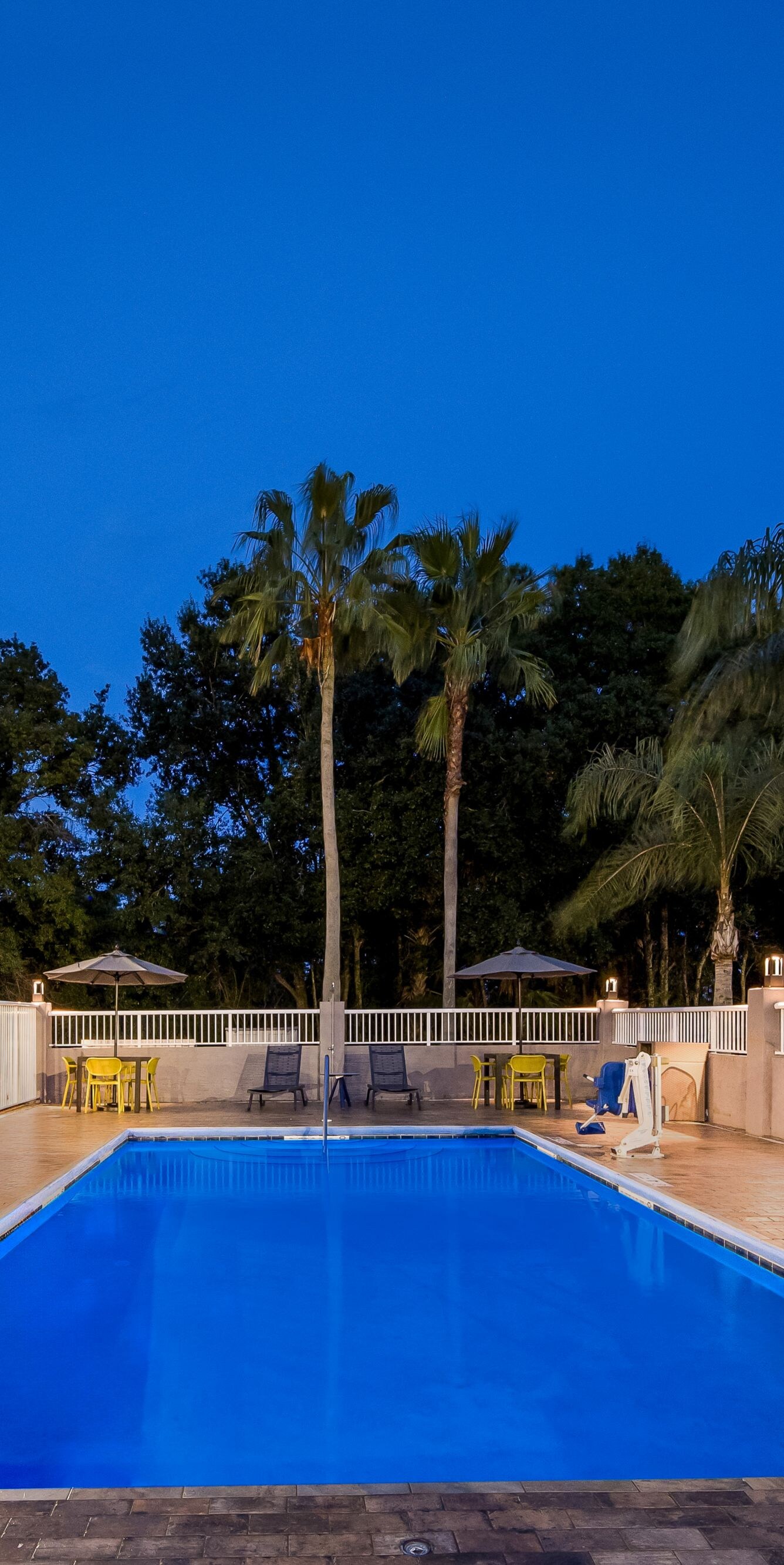 Outdoor pool surrounded by fenced paver deck