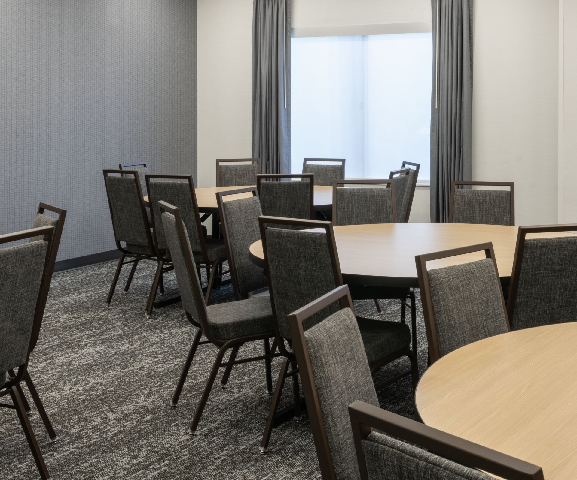 Round table meeting setup, chairs, TV, windows 