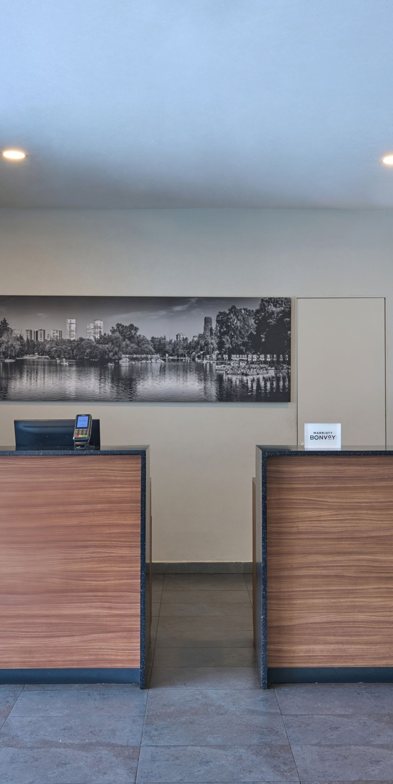 Mostrador de recepción con acabado en madera y obras de arte