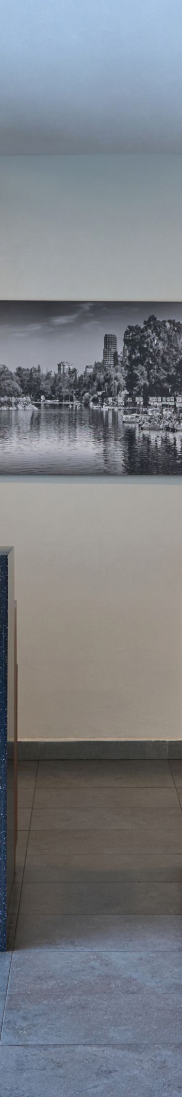 Mostrador de recepción con acabado en madera y obras de arte