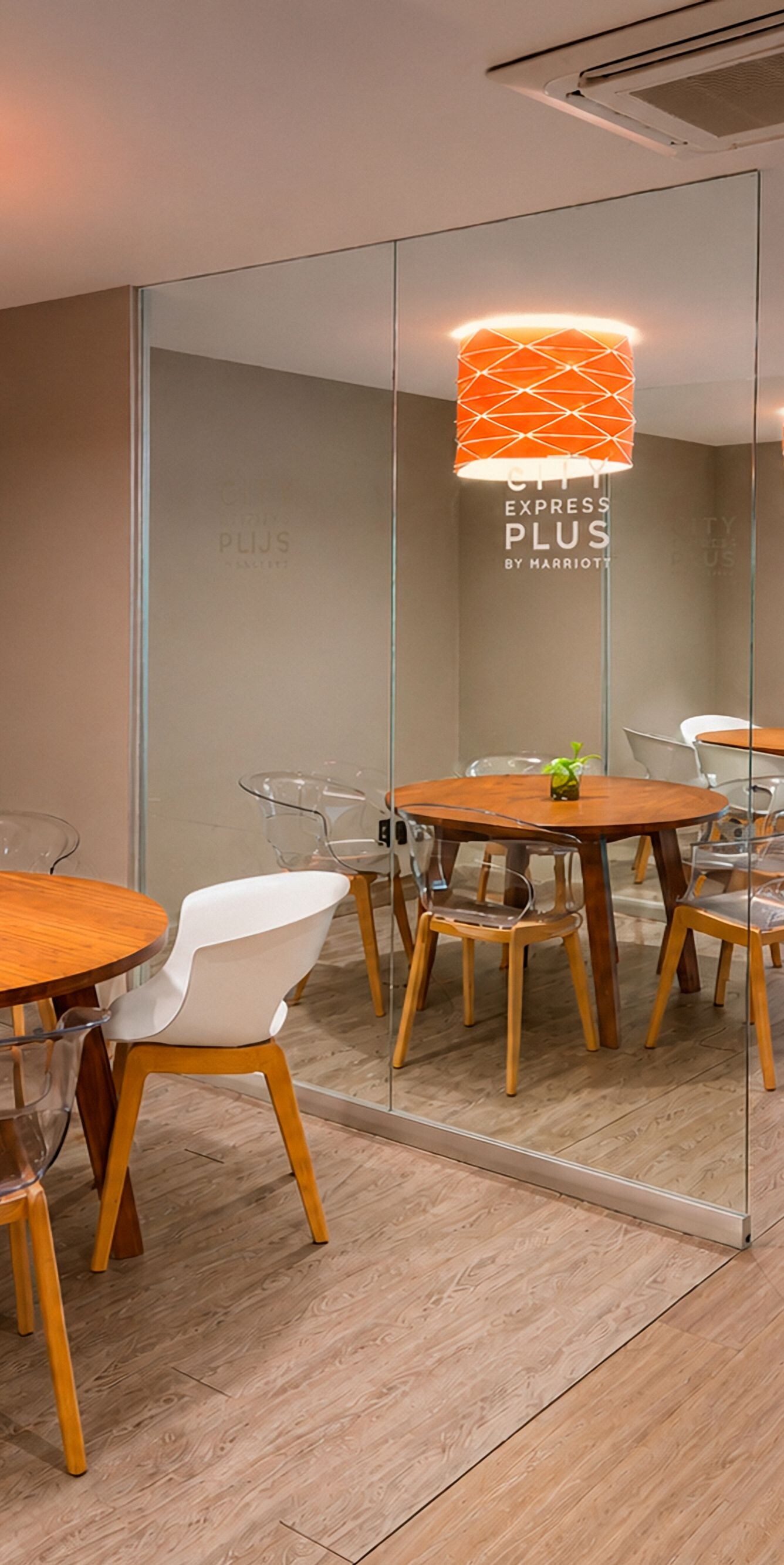 Mesa de comedor con sillas y pared de espejo