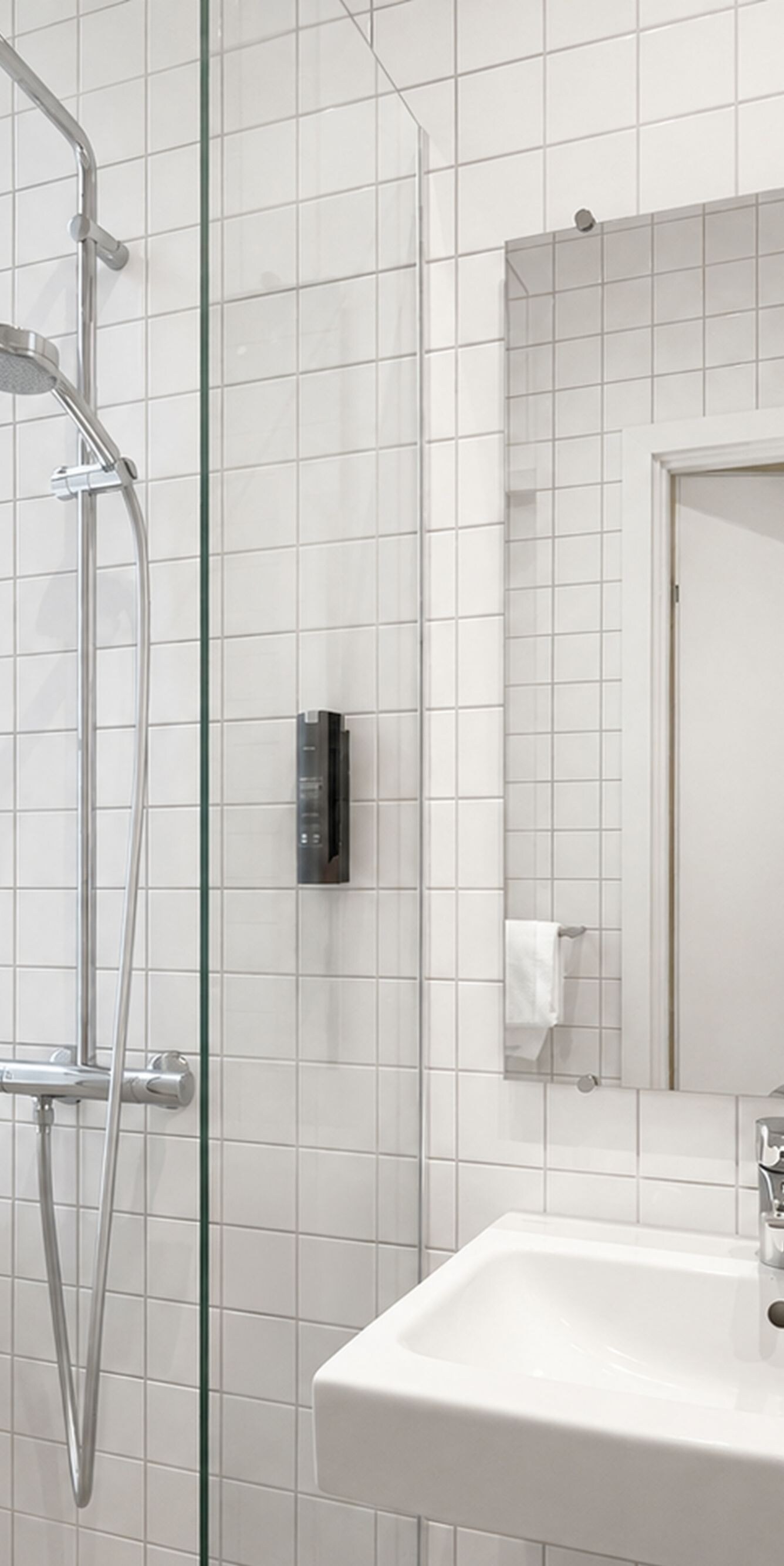 Moderne badeværelse med hvide fliser og bruser