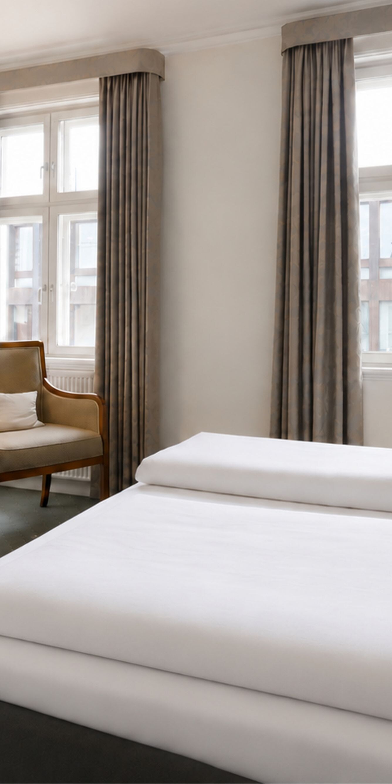 Hotelværelse med stor seng, skrivebord, stol og TV