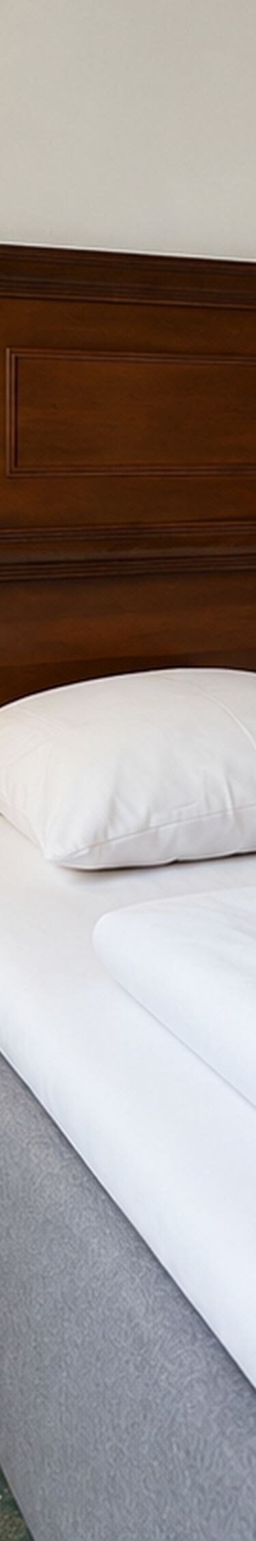 Gæsteværelse med queensize-seng og træmøbler