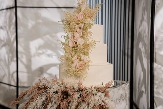 كعكة الزفاف المزينة بالزهور في قاعة احتفالات المظيف