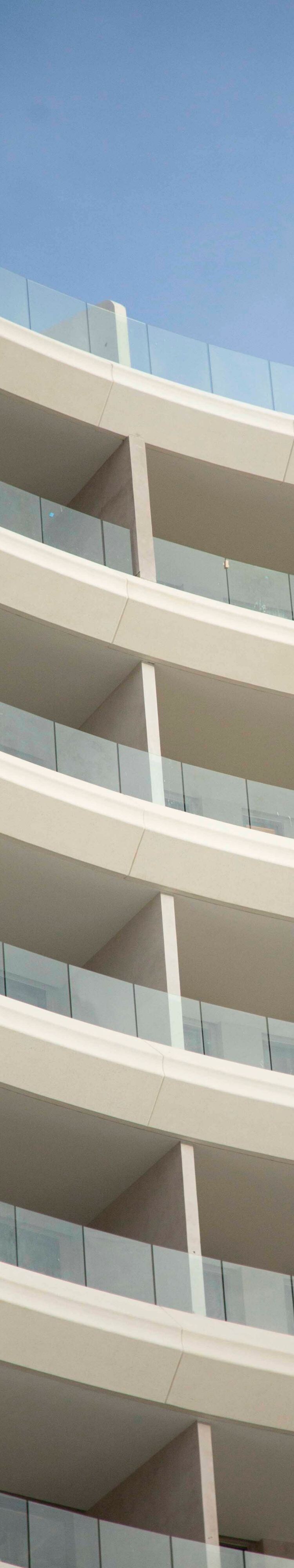 Exterior moderno del hotel con barandillas de cristal en los balcones