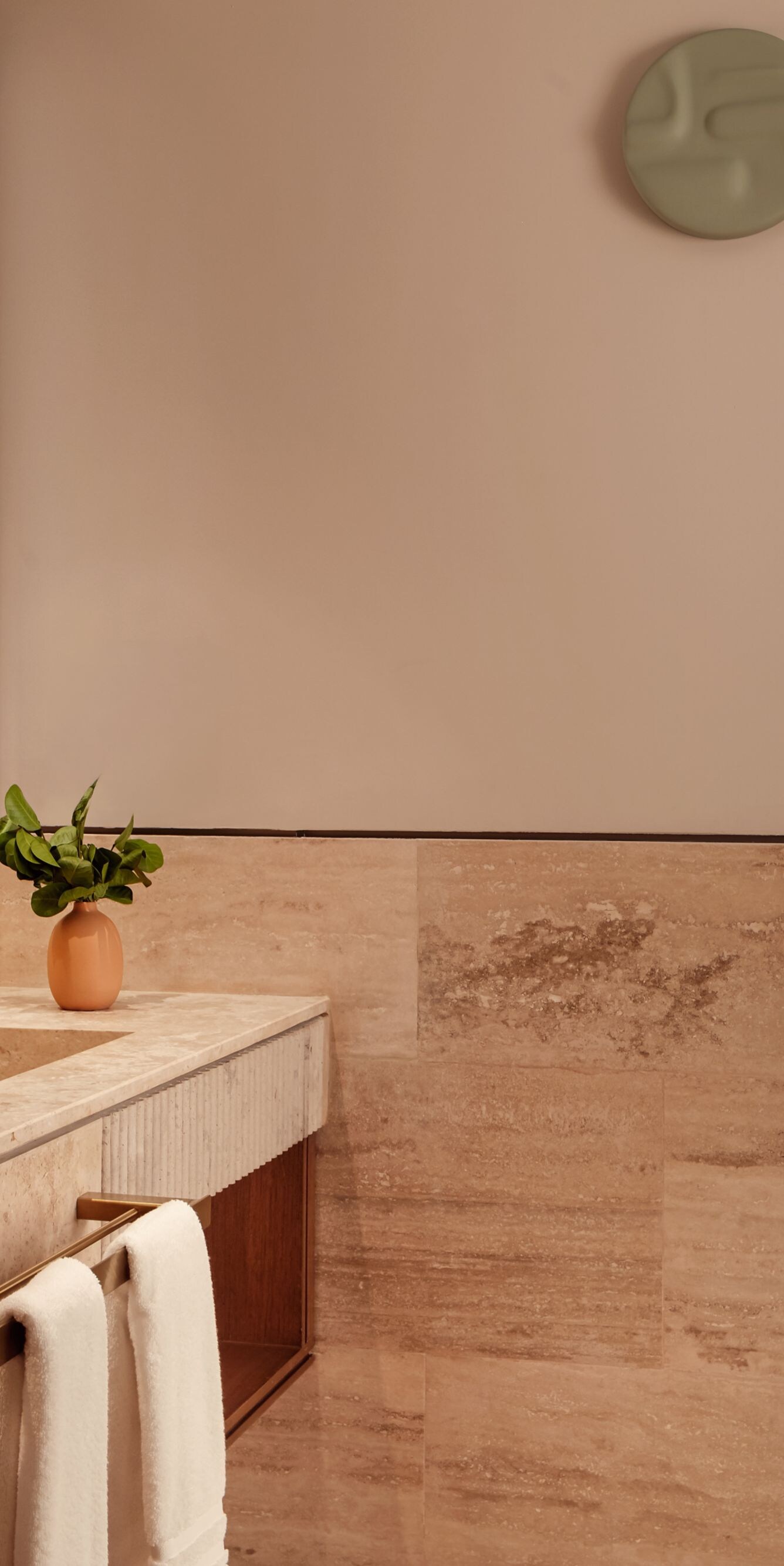 Baño con superficies de mármol y accesorios dorados