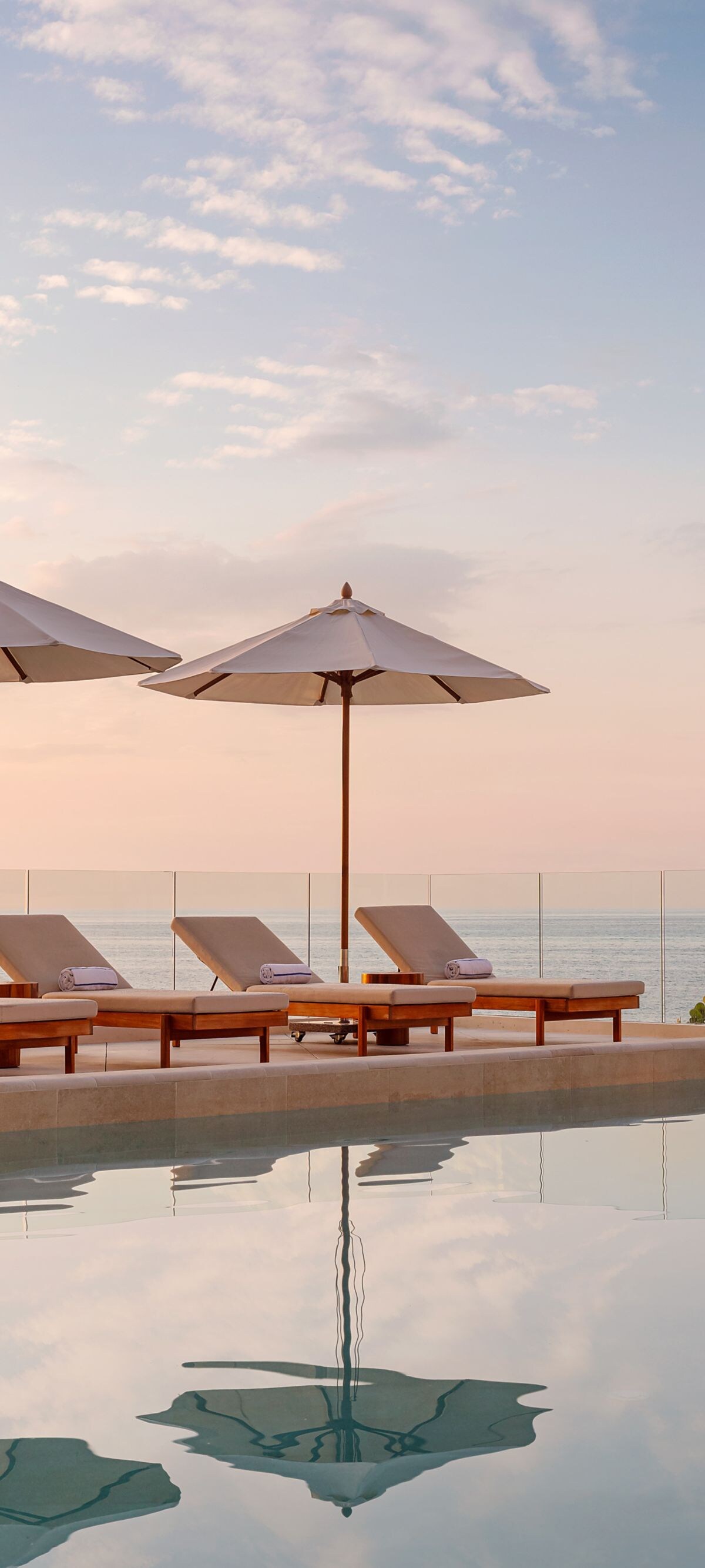 pool featuring loungers and umbrellas 