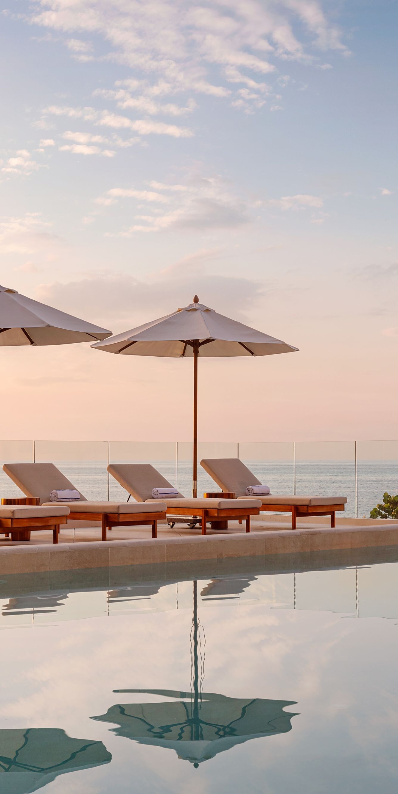 piscina con sillas reclinables y sombrillas 
