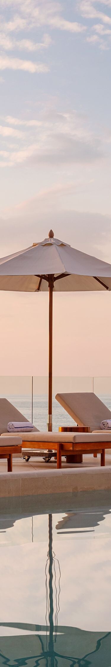 piscina con sillas reclinables y sombrillas 