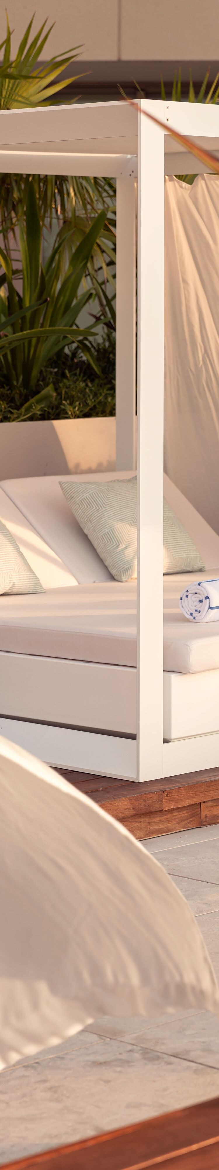 Cabaña junto a la piscina con una cama de día cubierta