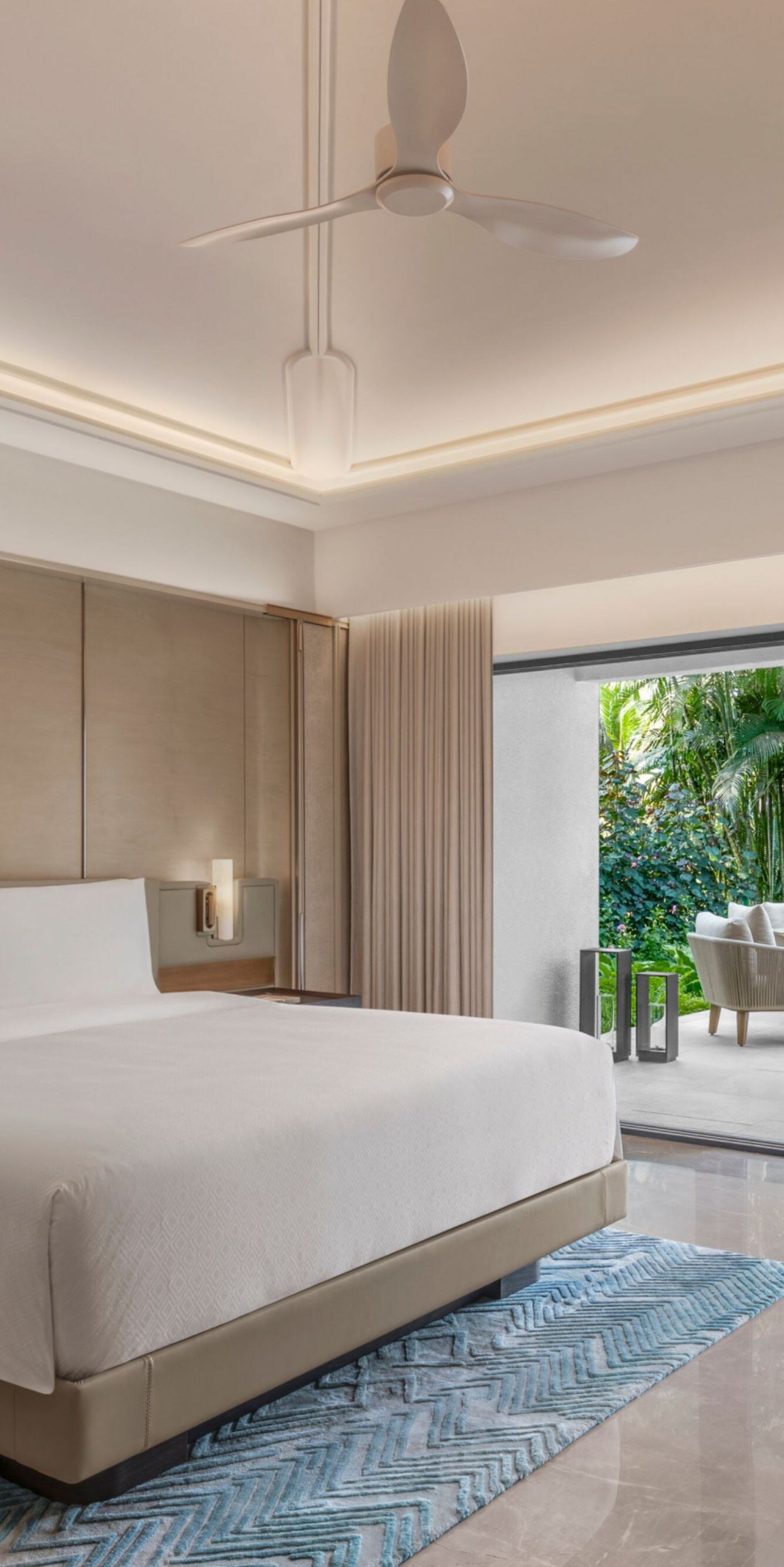 King bedroom with patio seating and garden view