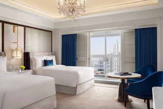 Twin beds in a large hotel room with a cityview