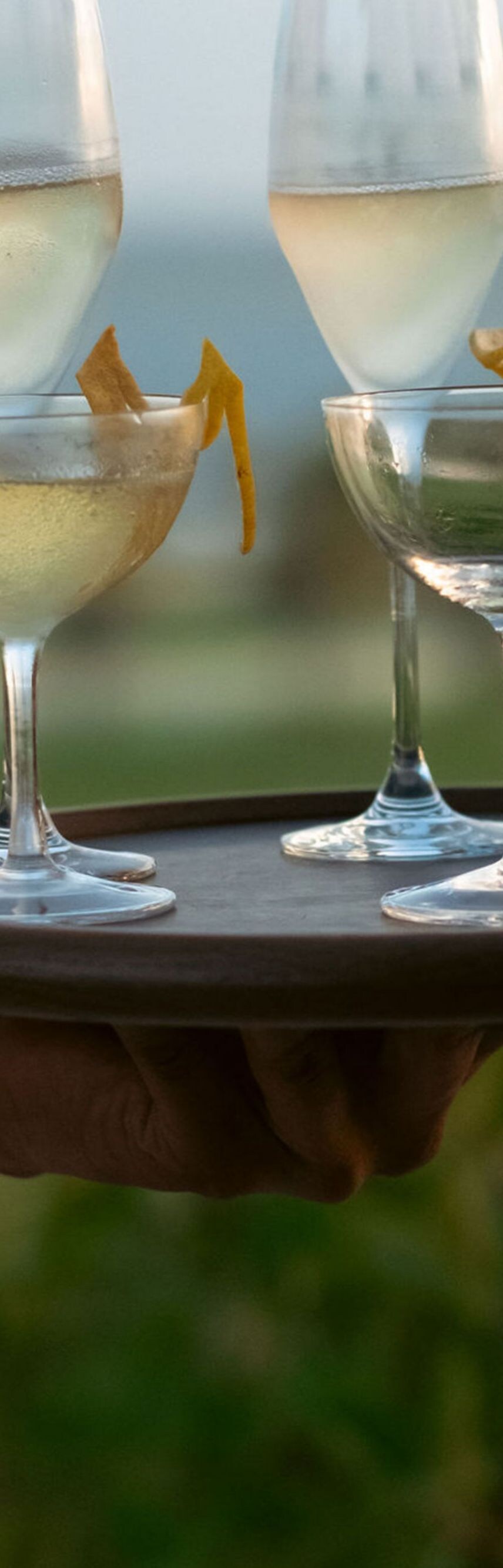 Server holding a tray with four champagne glasses