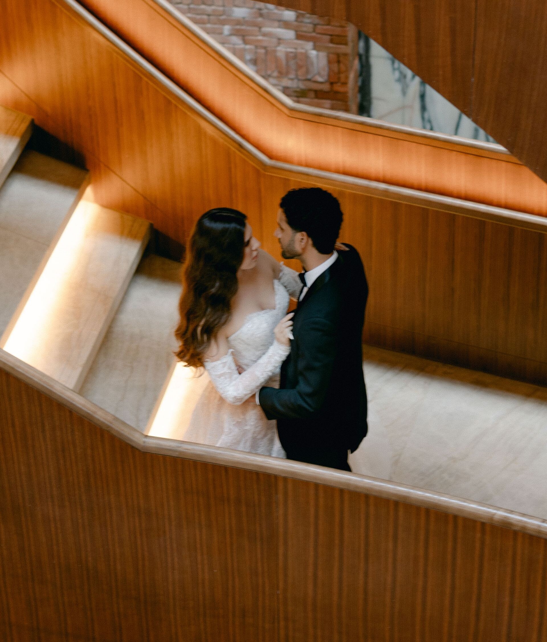 Couple in formal attire on illuminated staircase