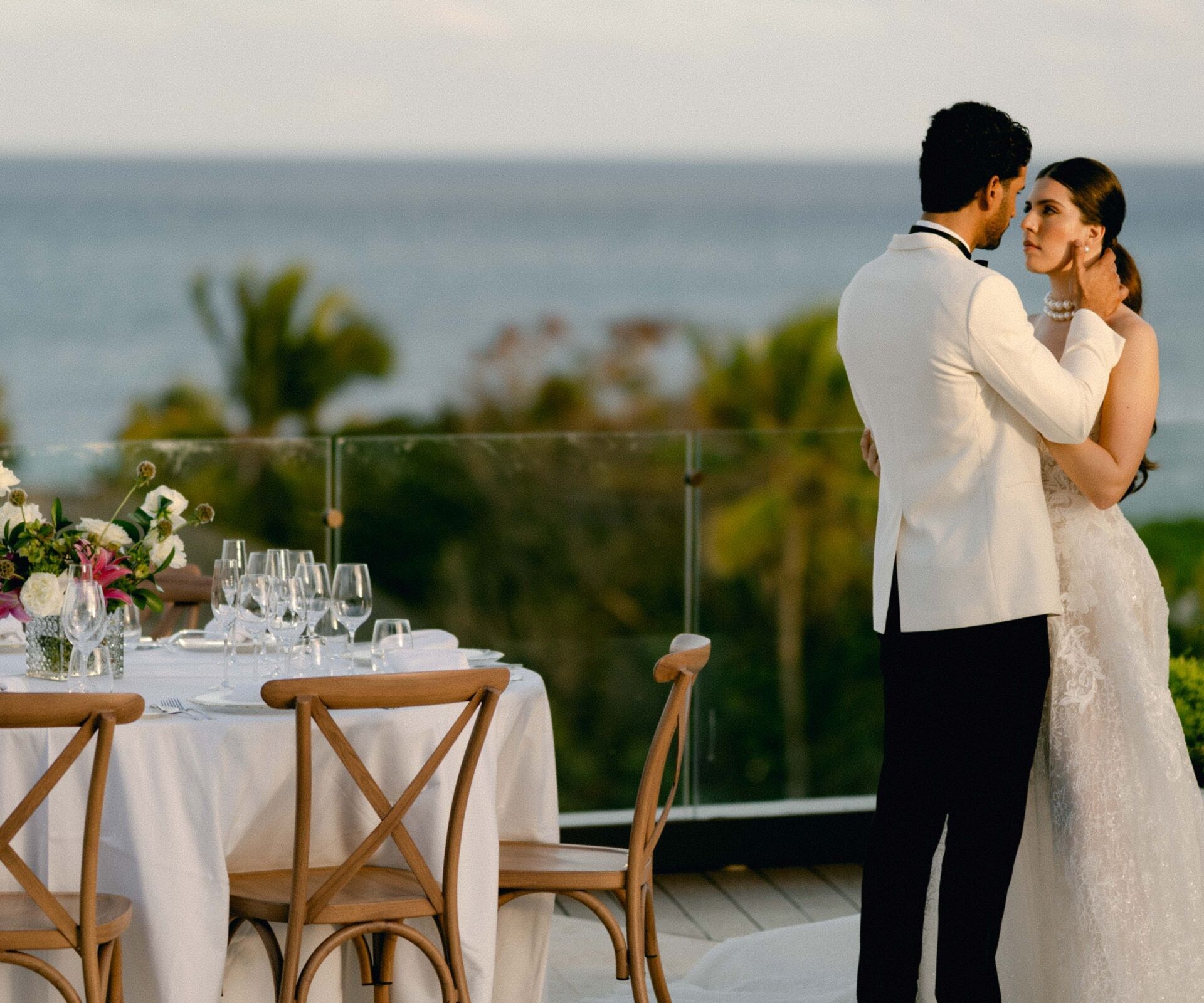 Couple in wedding attire embracing on terrace