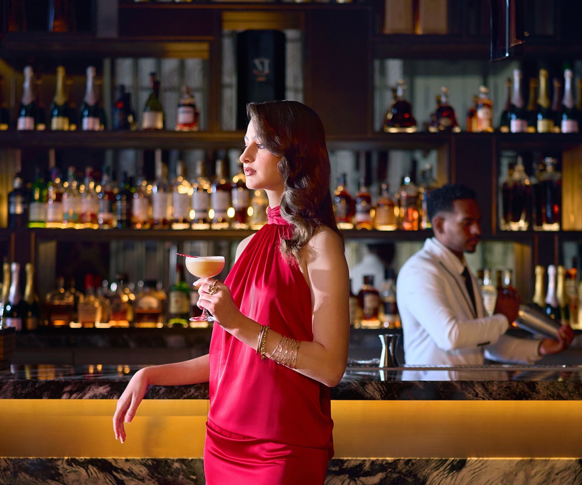 Woman in a red evening gown holding a cocktail at 