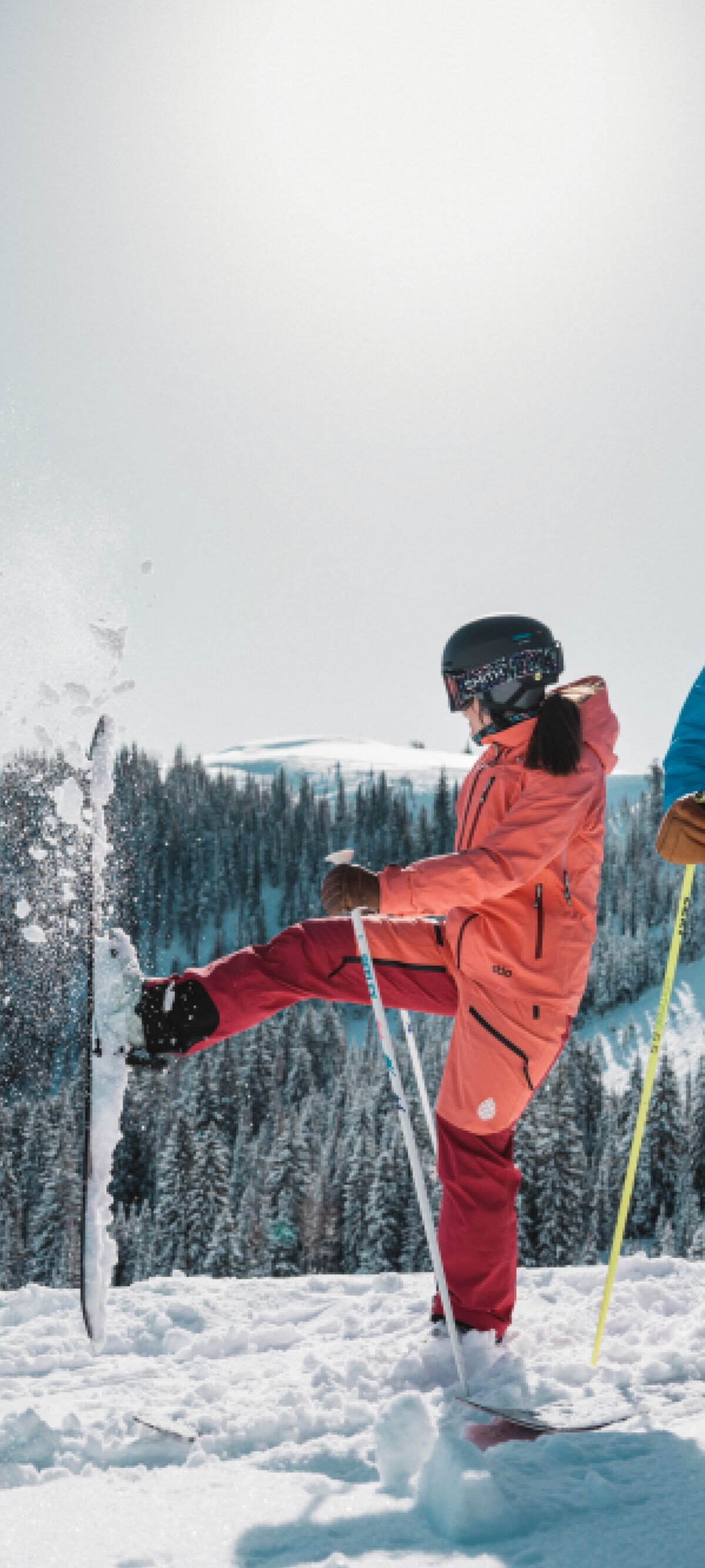 A couple cleans off their skis