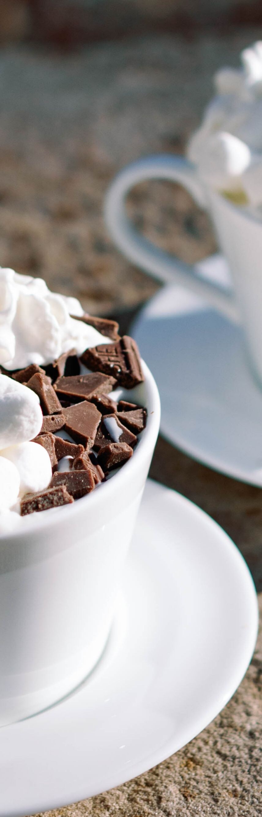 2 Hot Chocolate cups by an outdoor fire