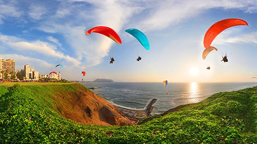 Parachutists floating above cliff and sea