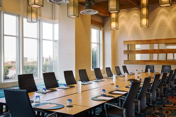 boardroom setting - long tables, chairs with notepads in front of each seat placement