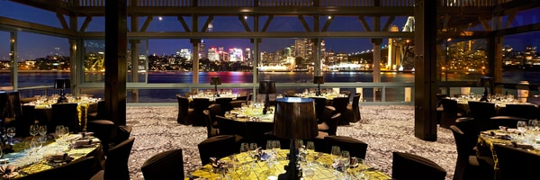 Outdoor dining at night overlooking river and cityscape