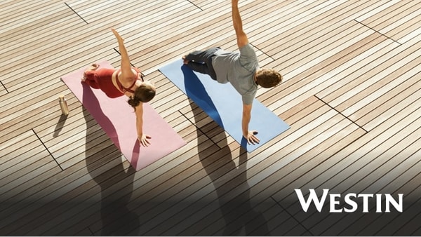 View from above of a man and woman doing side planks on yoga mats