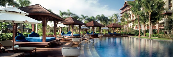 Covered lounges alongside a pool
