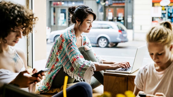 Three women online shopping in a coffee shop