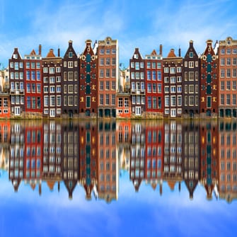 Tall colourful buildings lining the river in Amsterdam.