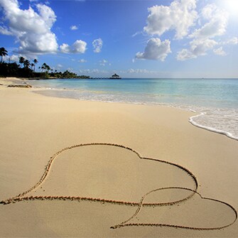 Hearts in the sand at a tropical Caribbean honeymoon destination near the ocean.