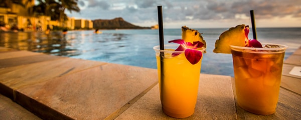 Close up view of fruity cocktails on a beach at sunset in Hawaii.