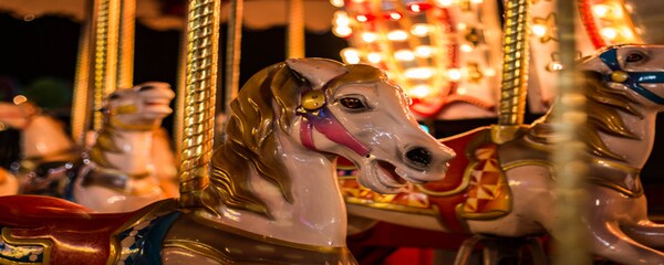 Lights shine on the face of a horse on the carousel ride in Santa Monica, California