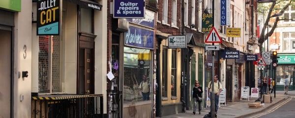 Signs mark the entrances to independent shops in Soho neighbourhood of London