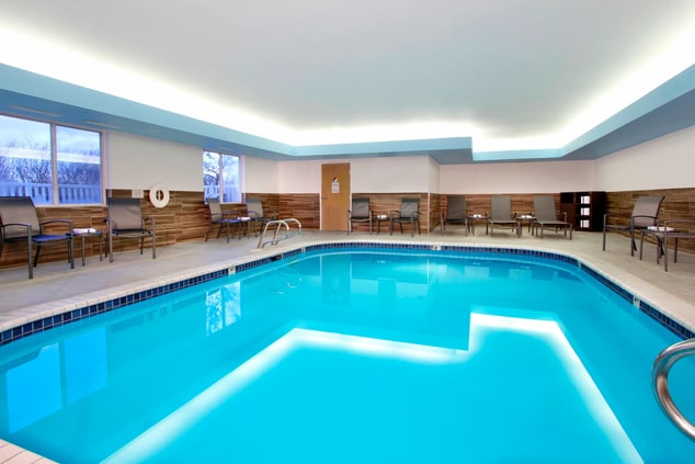large indoor pool surrounded by patio chairs