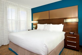 king-sized bed with crisp white linens and nightstands