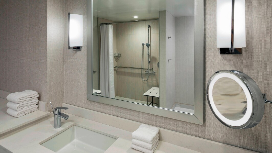 Banheiro com acomodações para hóspedes com mobilidade reduzida – chuveiro acessível por cadeira de rodas